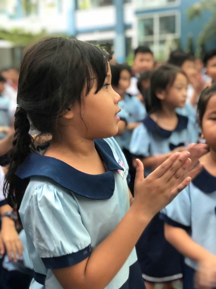 A group of children clapping Description automatically generated