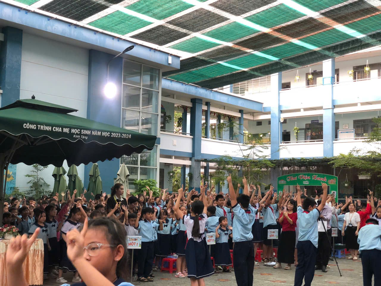 A group of students raising their hands Description automatically generated